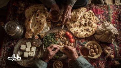 سفره‌ای ساده و صمیمی بر گلیم ایرانی؛ نانِ داغ، پنیر، گردو، سبزیِ معطر و دو فنجان چای که با دستان پینه‌بسته سالخوردگان چیده شده‌اند؛ یادگاری از ادبیاتِ طعم و خاطره‌ در فرهنگ ایرانی.